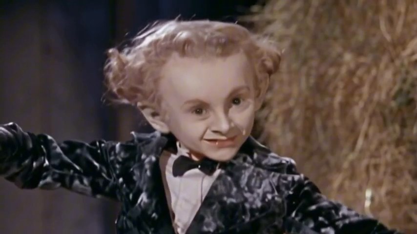 Velvet-suited dancer performing a tiptoe step and finger gesture